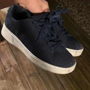 Svarta sneakers med vit sula - Snygga svarta sneakers med vit sula och klassisk snörning. Perfekta för en avslappnad stil.