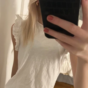 Vit blus från MNG - Säljer en söt vit blus i storlek S från Mango med spetsdetaljer på ärmarna. Säljer då den aldrig kommit till användning!🤍