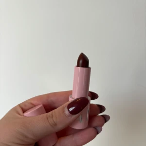 Mörk brun lipbalm caia - Snyggt mörkt läppstift med en elegant rosa hylsa. Perfekt för att ge en djärv look. Oanvänd såklart 