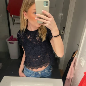 Mörkblå spetsblus - Snygg mörkblå spetsblus med korta ärmar och croppad design. Perfekt för en trendig look med jeans eller kjol. Blusen har ett vackert spetsmönster som ger en elegant touch. Pris kan diskuteras.💖