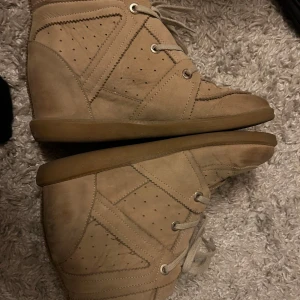 Beige isabel marants - Snygga beige sneakers med snörning. Isabel marant insperererade bobby skor. Skorna har en högre modell med en bekväm sula och är perfekta för en avslappnad stil.