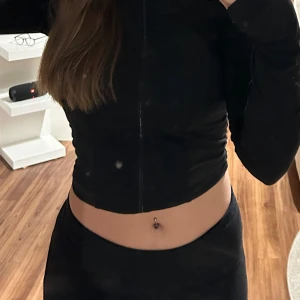 Svart croppad tröja med dragkedja - Snygg svart croppad tröja med dragkedja framtill. Perfekt för en trendig look.