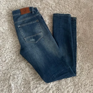 Buger jeans - Snygga blå jeans från Buger Limited Edition med slitna detaljer pågrund av att dom har blivit små på mig. Dom har en riktigt snygg passform och är köpta i Italen, inga defekter. Hör av dig vid frågor eller funderingar!