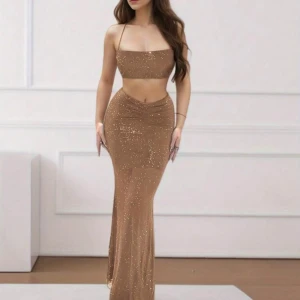 Glittrig beige långklänning - Snygg glittrig set med smala axelband och tight passform. Perfekt för festliga tillfällen med sin eleganta och glamorösa look. Använd max 1 gång men i väldigt gott skick