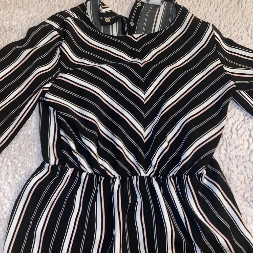 Snygg randig blus från Primark i svart, vit och rosa. Blusen har långa ärmar och en elastisk midja för en bekväm passform. Perfekt för både vardag och speciella tillfällen.. Puserot.