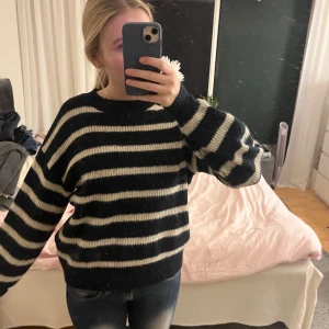 Randig stickad tröja - Säljer en mysig stickad tröja med marinblåa och vita ränder. Tröjan har en avslappnad passform och långa ärmar, perfekt för kyligare dagar. Den är både stilren och bekväm. Skriv om ni har några frågor!💞