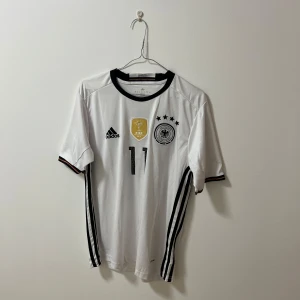 Tyskland fotbollströja ”Reus” - Säljer en snygg Tyskland fotbollströja med Reus på ryggen. Tröjan är från 2014 då de vann VM och krossade Brasilien i finalen, detta gör tröjan väldigt sällsynt⚽️🏆 