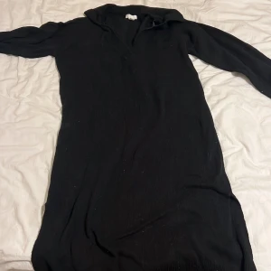 Svart långklänning - Elegant svart långklänning med långärmad design. Perfekt för en stilren look. Klänningen har en enkel och klassisk stil som passar till många tillfällen.