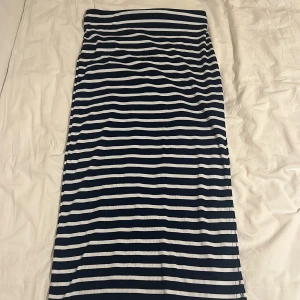 Randig långkjol - Snygg långkjol med marinblå och vita ränder. Perfekt för en stilren look. Kjolen har en rak passform och är gjord i ett mjukt och bekvämt material.