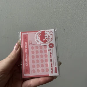 30-dagars utmaningskort - Säljer ett set med 30-dagars utmaningskort från BENSTORE. Korten är rosa och vita med ett sött tecknat motiv. Perfekt för att hålla koll på dina mål och utmaningar under en månad. Varje kort har plats för att skriva mål och följa framsteg dag för dag.