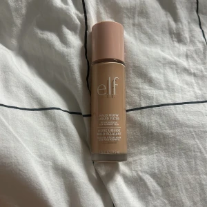 e.l.f. Halo Glow Liquid Filter - Säljer en e.l.f. Halo Glow Liquid Filter i nyansen Light/Medium. Denna flytande produkt ger en strålande finish och kan användas som foundation eller highlighter. Kommer i en praktisk flaska med applikator för enkel applicering. Använd bara en gång 💕
