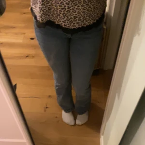 Blå jeans - Säljer ett par klassiska blå jeans med låg midja och bootcut-stil. Perfekta för en avslappnad look. De har en snygg passform och är tillverkade i ett bekvämt denimtyg.