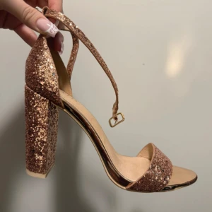 Glittriga sandaler med klack från Raid klackskor - Snygga glittriga sandaler från Raid med hög klack och öppen tå. Perfekta för en festlig kväll med sina glittrande detaljer och justerbara remmar.