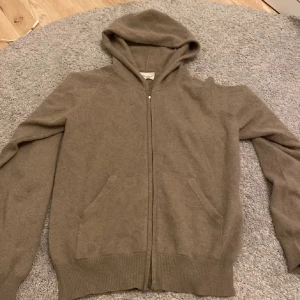 Liknande soft goat zip up äkta cashmere - Mysig beige hoodie från Zara i mjuk kashmir. Tröjan har en dragkedja framtill och praktiska fickor. Perfekt för kyliga dagar med sin bekväma passform och långa ärmar.