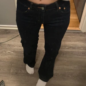 Svarta jeans med låg midja - Snygga mörkblå jeans med mid rise. Jeansen är 90 tals boot från lager 157. De har knappar på bakfickorna och har en brunare tråd till sömmarna som man ser på bilderna. De är inte använda så mycket och är nästintill i nyskick.