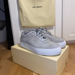 Gråa sneakers - Axel Arigato - Tjena! Säljer nu dessa snygga grå sneakers från Axel Arigato i mocka med vit sula. Skorna är endast använda ett fåtal gånger och är i mycket bra skick. Levereras med originalförpackning och dustbag.       Det finns en liten defekt (tuggummi) på undersidan av ena sulan som är relativt enkelt att ta bort.              |Storlek: 43| |Nypris: 2500 kr| |Mitt pris: 799 kr| (öppen för prisförslag) Tveka inte att höra av dig om du har några frågor eller vill se fler bilder!