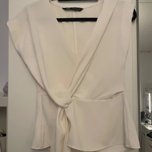 Vit omlottopp från Zara - Snygg vit omlottopp från Zara med knytning i midjan. 