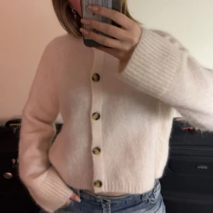 Other stories beige kofta - Mysig vit kofta med stora knappar framtill. Den har långa ärmar och en enkel design som passar perfekt för kyligare dagar. Perfekt att matcha med jeans för en avslappnad look. Köpt i London för 1000+ ❤️