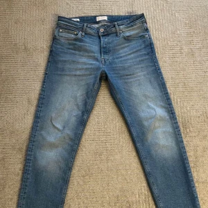 Blå jeansbyxor HELT NYA - Snygga blå jeansbyxor med en klassisk femficksdesign och knappgylf. De har en lätt tvättad look och normal passform. Perfekta för en avslappnad stil. HELT NYTT rak passform 