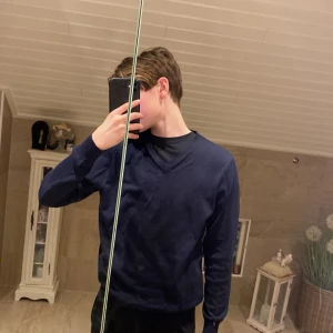 Mörkblå tröja från Dressmann - Säljer en stilren mörkblå tröja från Dressmann. Tröjan har en v-ringad hals och långa ärmar, perfekt för en klassisk look. Passar bra till både jeans och chinos. Hör av dig vid intresse! Storlek:s herr. 10/10 skick, nästan aldrig använt🤙