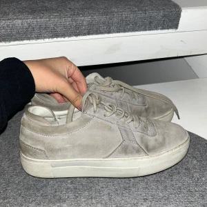 Gråa sneakers från Axel Arigato - Snygga gråa sneakers från Axel Arigato i mocka med vit sula, storlek 38. Nypris:2500 säljs för 1750