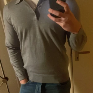 Grå tröja från Drumohr - Säljer en stilren grå tröja från Drumohr. Tröjan har en klassisk krage och knappar framtill. Perfekt för en avslappnad men ändå elegant look. Passar bra till jeans eller chinos.   Nypris 4,2 , kom med bud.    Den är som en medium/large.   Storlek 50 