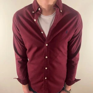 Vinröd Ralph Lauren skjorta -  Nu säljer vi ännu en fet polo skjorta som passar till alla tillställningar och skjortan är i bra skick men är lite urtvättad vid sömmarna! Du ska kunna uttrycka stil utan att det kostar för mycket!🕺🍾💼🤩  Storlek👔: S Nypris💰: 1499