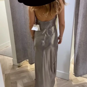 Silvrig långklänning med smala axelband - Superfin långklänning ifrån Massimo Dutti oanvänt med lapp kvar. Passar perfekt till bal eller annan fest❤️‍🔥skriv för flera bilder. Pris kan diskuteras