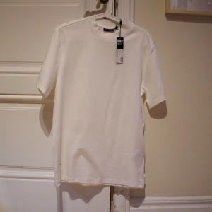 Vit J. Lindeberg t-shirt med krage  - Jätte snygg J-Lindeberg t shirt med en lite starkare krage. Super modern look, och materialet är super lyxigt och skönt. Köpt för 900 kr, aldrig använd pågrund av att den är för stor på mig. Sitter som en S eller lite större XS