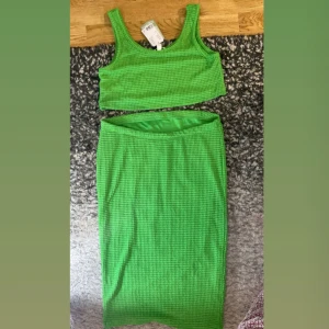 Grön sätt från H&M - Snygg grön sätt med kjol och linnetopp från H&M. Perfekt för en somrig look med sin fräscha färg och bekväma passform. Matcha med kjolen för en komplett outfit!