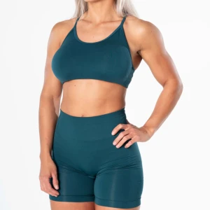 Mörkgrönt träningsset ifrån relode - Snygga mörkgröna träningsshorts och sporttopp ifrån relode. Det är scrunch vid rumpan på shortsen och sporttoppen är korsad fint där bak! Inte använda super många gånger så det är i väldigt bra skick! Nypriset på dem är 499kr  för toppen och 579kr för shortsen, mitt pris är 500kr för båda🥰skriv för egna bilder! Båda delarna är i storlek small