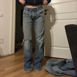 Blå jeans från Diesel - Säljer ett par klassiska blå jeans från Diesel med en straight passform. De har en dragkedja och knapp framtill samt fem fickor. Perfekta för en avslappnad stil. Nere på ena benet är det några små målarfärgsfläckar som inte går bort i tvätten men det är ingenting man tänker på.