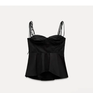 Svart topp  - Snygg populär svart topp från Zara med smala axelband och volangdetalj nedtill. Toppen har en figurnära passform och en elegant design som passar perfekt för en kväll ute. Den är helt slutsåld på hemsidan och prislappen kvar, därav priset💕Öppen för prisförslag☺️