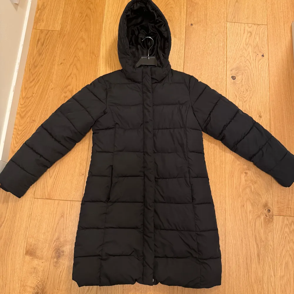 Säljer en svart lång dunjacka från Lager 157. Storlek 160 men passar mig som brukar ha xs och är 158 cm. Tillverkad i 100% polyester vilket gör den både varm och lätt. Fint skick förutom lite avskaft på dragkedjan (se sista bild) . Takit.