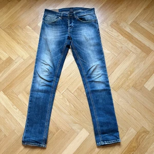 Blå jeansbyxor - Snygga blå jeansbyxor från Dondup med slitna detaljer. Byxorna har en dragkedja och knapp framtill. Perfekta för en avslappnad stil.