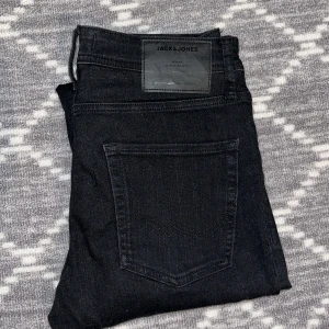 Svarta jeans från Jack & Jones - Säljer dessa riktigt svarta Jack & Jones jeans! Säljer pga dom aldrig kommer till användning. Skick: 10/10 använt få tal gånger. Storlek: 30/30. Priset är ej hugget i sten