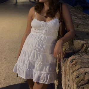 Vit sommarklänning med volanger💐😇 - Säljer min älskade vita klänning från Gina som är så himla söt men kommer nog inte använda i sommar! Bara använts två gånger 🥰🥰 det är min kompis på bilden!!