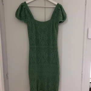 Grön stickad klänning från NA-KD - Säljer en superfin grön stickad klänning från NA-KD. Den har en tight passform med korta puffärmar och ett vackert hålmönster. Perfekt för vår och sommar! 💚Klänningrn har aldrig använts men tyget har gått upp lite. Prislapp kvar på den. 