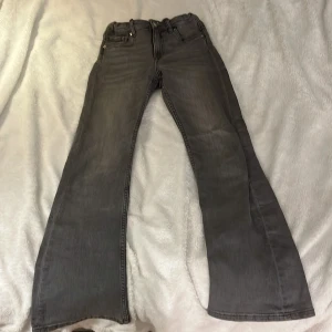 Grå bootcut jeans - Snygga grå bootcut jeans med klassisk femficksdesign. Perfekta för en avslappnad stil. Det är i storlek 146. Tvättade innan den blir skickad.