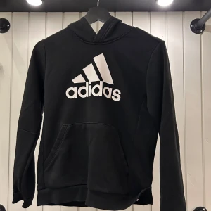 Adidas Hoodie Junior - Skick är bra - 8.5/10. Använd en del men inget som syns så tydligt. Köpt på Stadium för 350kr.   Öppen för prisförslag och tveka inte på att höra av dig vid minsta fundering.