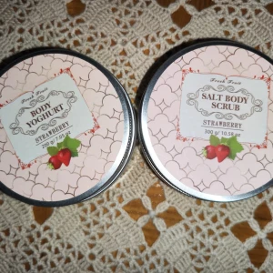 Body Yoghurt och Salt Body Scrub med Jordgubbsdoft - Säljer två härliga produkter från Claudia Cosmetics med jordgubbsdoft. Den första är en Body Yoghurt som är perfekt för att återfukta huden och ge den en mjuk känsla. Den andra är en Salt Body Scrub som exfolierar huden och lämnar den silkeslen. Båda produkterna kommer i snygga burkar med ett rosa mönster och har en vikt på 300 g vardera. Perfekt för en lyxig hemmaspa-upplevelse!