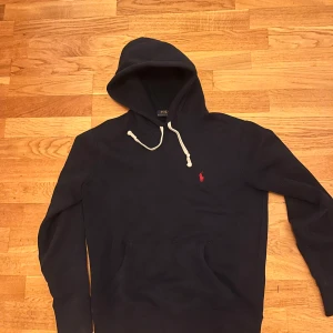 Ralph Lauren Hoodie - Ralph Lauren hoodie i XS sitter typ som en S!  Skick 9/10 den är använd men inget annars. Är typ blå/svart! Skriv vid fundering, Priset är ej hugget i sten!