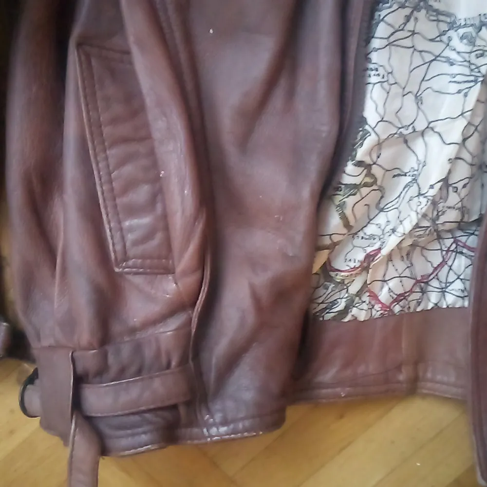 Säljer en snygg brun skinnjacka från H&M. Jackan har en cool vintage-look med en unik kartmönstrad insida. Den har långa ärmar och praktiska fickor med knappar framtill. Perfekt för höst och vår!. Takit.