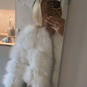 Vit pälsjacka - Säljer en superfluffig åt min vän, den är mysig o vit pälsjacka. Perfekt för att hålla sig varm och stilren under kyliga dagar. Jackan har en oversized passform och är långärmad, vilket gör den både bekväm och trendig. den är liten i storleken