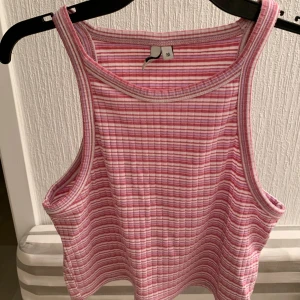 Linne - Randigt flerfärgat linne. Linnet är använt flertal gånger men är i bra skick utan defekter. Linnet är i storlek M. Stretchigt material.