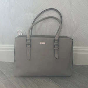 Väska - Superfin väska från rizzo med märket don donna. Köpt för flera år sen men har knappt kommit till användning så i bra skick. Finns en liten defekt på ena handtaget men som är på undersidan så de syns inte när man använder den. (Se bild 4) 