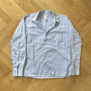 Skjorta Comme des Garçons - Blå och vitrandig Comme des Garçons SHIRT i strl. M. Toppskick.
