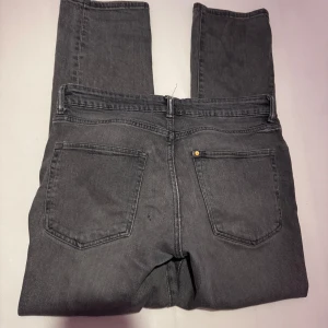 Grå jeansbyxor - Snygga grå jeansbyxor med en klassisk femficksdesign. De har en dragkedja och knapp framtill. Perfekta för en avslappnad stil. Modellen är straight och storlek 31 -32 , liten skada där skärpet ska sitta