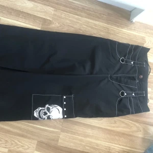 Svarta byxor med dödskalle - Coola svarta byxor med ett stort dödskallemotiv på benet. Tunnt material💗