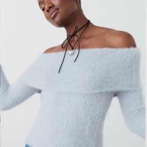 Ljusblå offshoulder tröja - Säljer en supermjuk ljusblå offshoulder tröja med lång ärm. Perfekt för en stilren och bekväm look. Tröjan har en fluffig textur som ger extra mysfaktor.